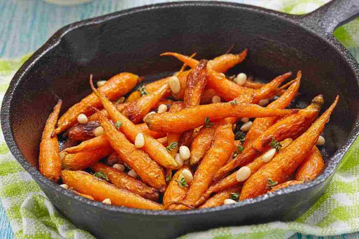 Roasted carrots with rosemary and pine nuts in a pan, so tempting as to be irresistible - RicettaSprint.it